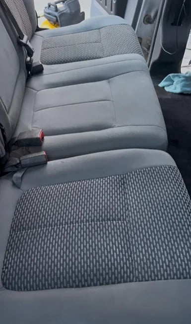Interior view of a vehicle showing gray fabric and leather seats in a row, photographed from above